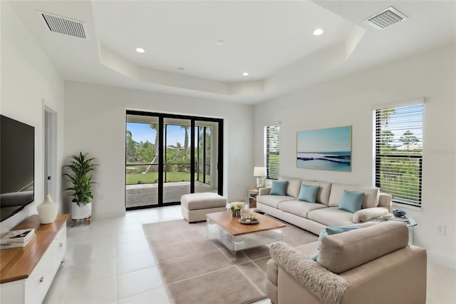 living room with a raised ceiling and a wealth of natural light