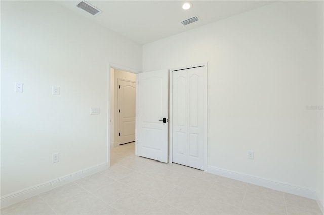 unfurnished bedroom with light tile patterned floors and a closet