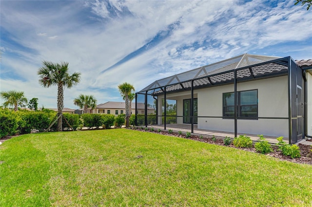 view of yard featuring glass enclosure and a patio