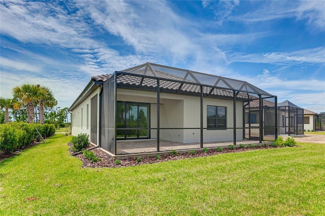 rear view of house with a patio, a lanai, and a lawn