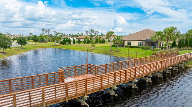 dock area with a water view and a lawn