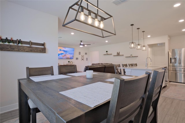 dining space featuring sink, light hardwood / wood-style floors, and ceiling fan