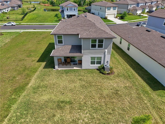 exterior space featuring a patio area, a garage, a yard, and central air condition unit