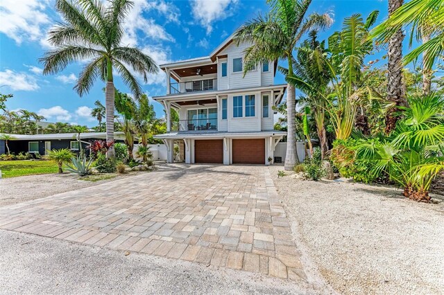 coastal inspired home with a garage and a balcony