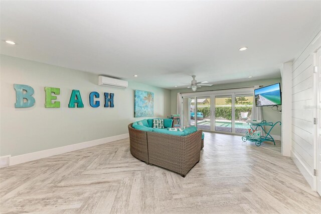 living room with light parquet floors, ceiling fan, and an AC wall unit