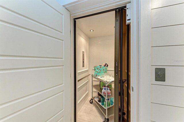 interior details with light tile flooring and elevator