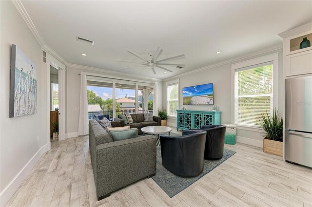 living room with light hardwood / wood-style flooring, crown molding, and ceiling fan