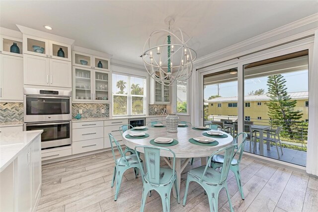 dining space featuring a notable chandelier, crown molding, and light hardwood / wood-style floors