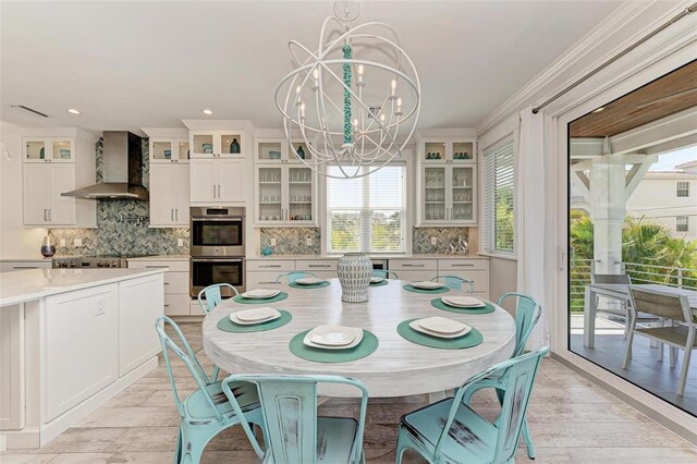 dining area with ornamental molding and an inviting chandelier