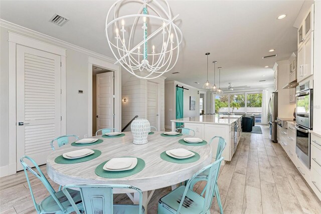 dining area featuring a chandelier, ornamental molding, and light hardwood / wood-style flooring