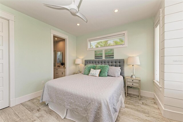 bedroom with connected bathroom, light hardwood / wood-style flooring, and ceiling fan