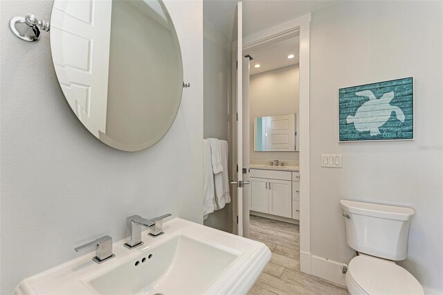 bathroom featuring vanity, toilet, and hardwood / wood-style flooring