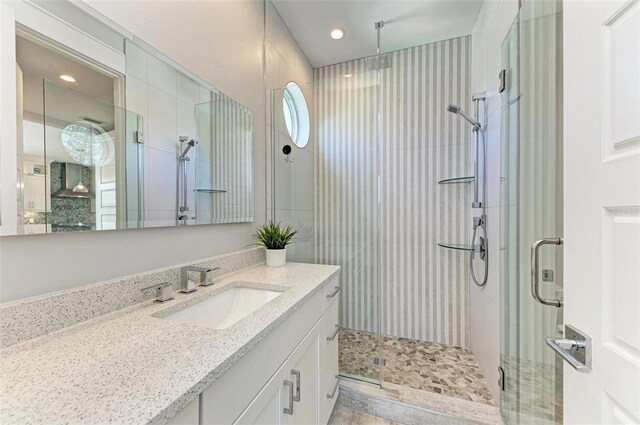 bathroom featuring oversized vanity and a shower with shower door