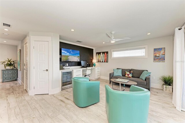 living room with wine cooler, light hardwood / wood-style flooring, and ceiling fan