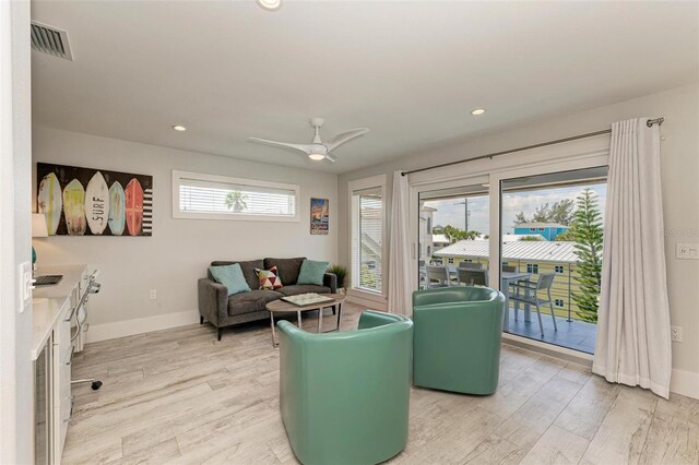 living room with ceiling fan and light wood-type flooring