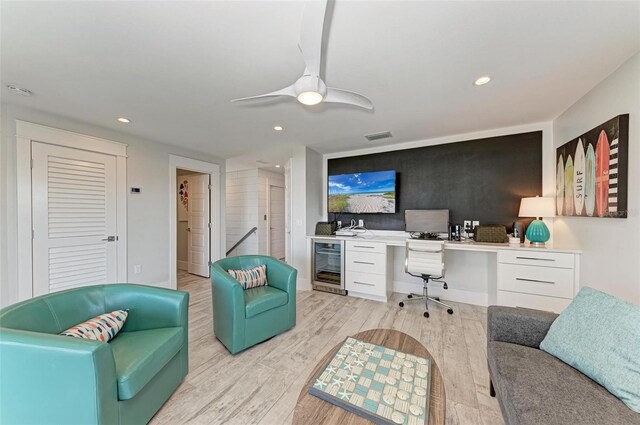 office space featuring light hardwood / wood-style flooring, ceiling fan, and beverage cooler