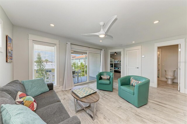 living room with ceiling fan and light wood-type flooring