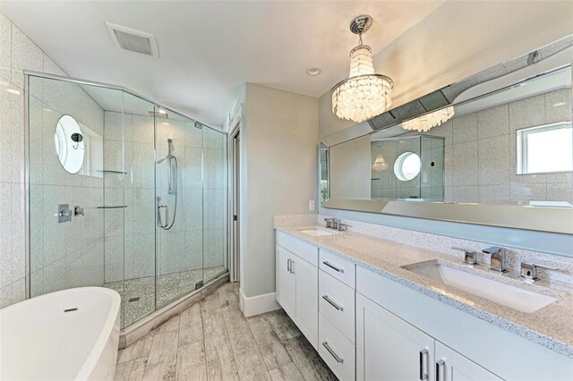 bathroom featuring dual sinks, oversized vanity, separate shower and tub, and hardwood / wood-style flooring