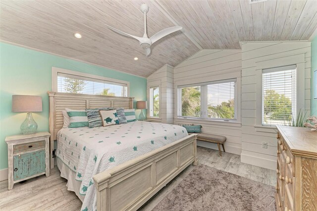 bedroom with wooden walls, light wood-type flooring, vaulted ceiling, wood ceiling, and ceiling fan