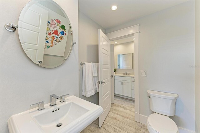 bathroom featuring vanity, hardwood / wood-style flooring, and toilet