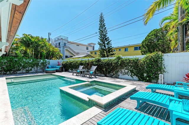 view of swimming pool featuring a patio, pool water feature, and an in ground hot tub