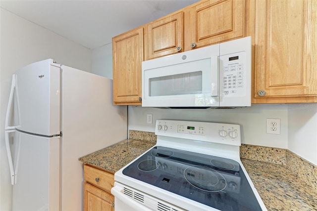 kitchen featuring light brown cabinetry and white appliances