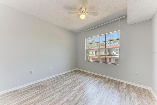 unfurnished room with light hardwood / wood-style floors, ceiling fan, and a textured ceiling