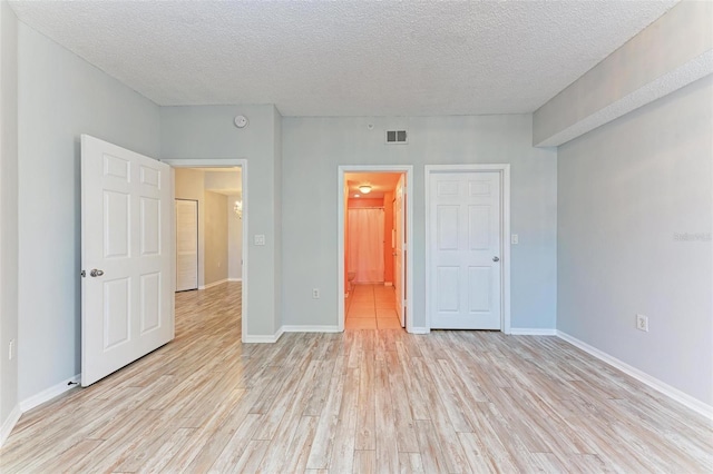 unfurnished bedroom featuring light hardwood / wood-style flooring and a textured ceiling