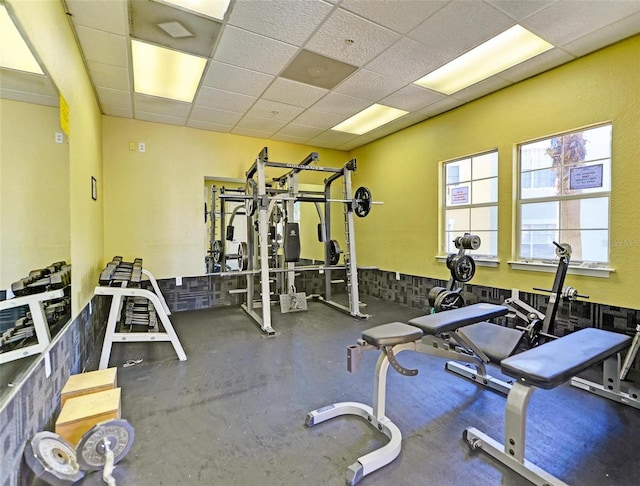 exercise room featuring concrete floors and a paneled ceiling