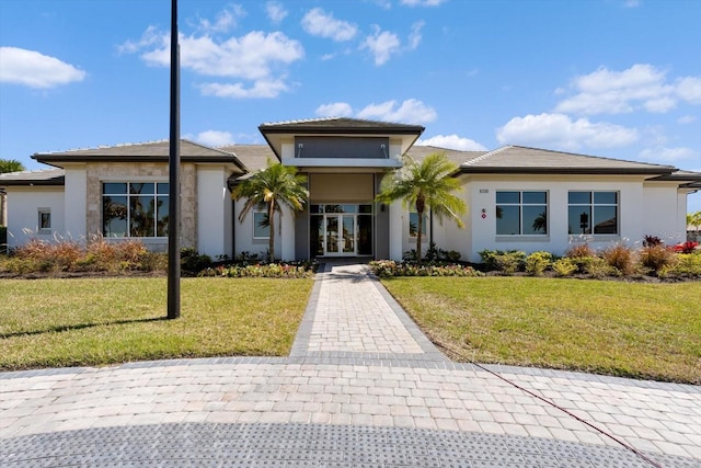 view of front of property with a front yard and french doors