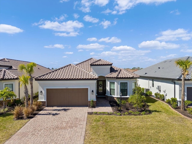 mediterranean / spanish-style home featuring a garage and a front yard