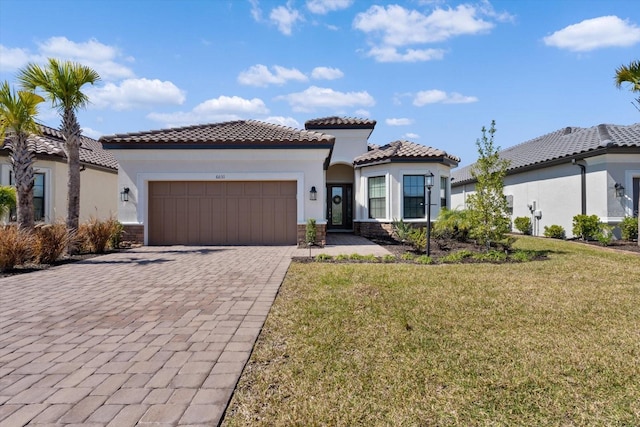 mediterranean / spanish house featuring a garage and a front yard