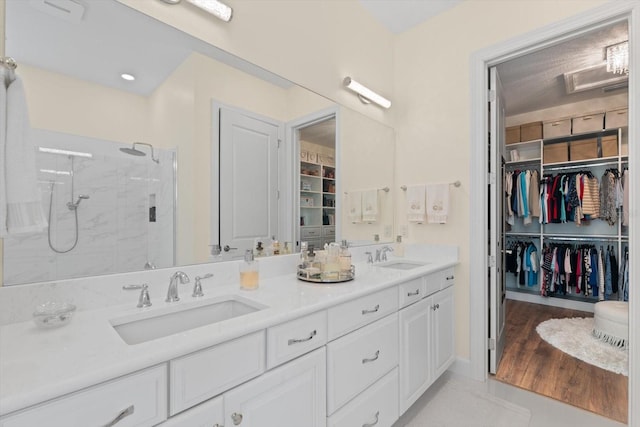 bathroom with hardwood / wood-style floors, vanity, and walk in shower