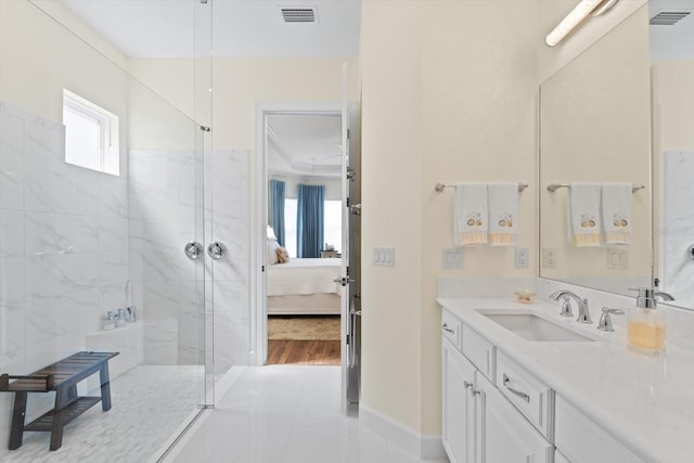 bathroom with tile patterned flooring, a tile shower, and vanity