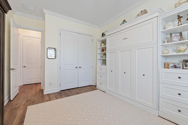 unfurnished bedroom with dark hardwood / wood-style floors, a closet, and crown molding