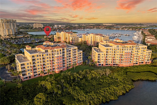 aerial view at dusk featuring a water view