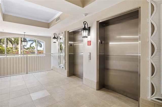 corridor with crown molding, elevator, a raised ceiling, and light tile flooring