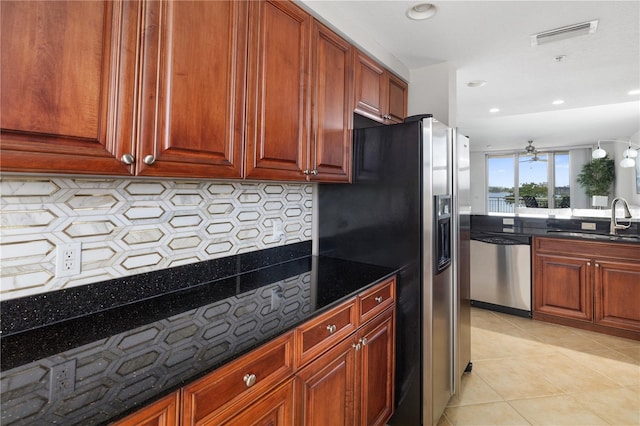 kitchen with light tile floors, sink, dishwasher, backsplash, and dark stone countertops