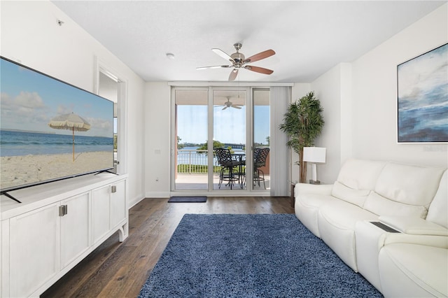 unfurnished living room with a water view, ceiling fan, and dark hardwood / wood-style flooring