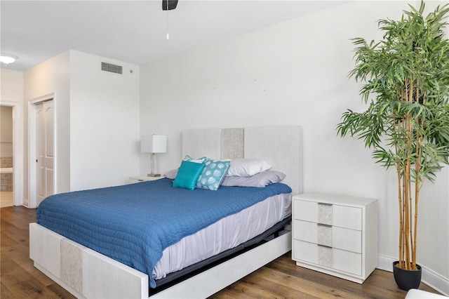 bedroom with dark hardwood / wood-style flooring and a closet