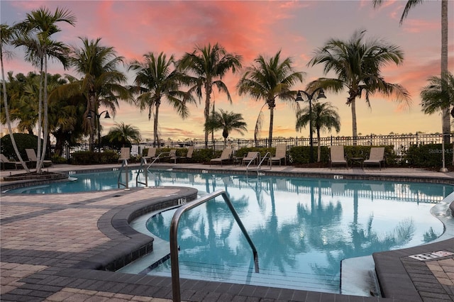 pool at dusk featuring a patio area