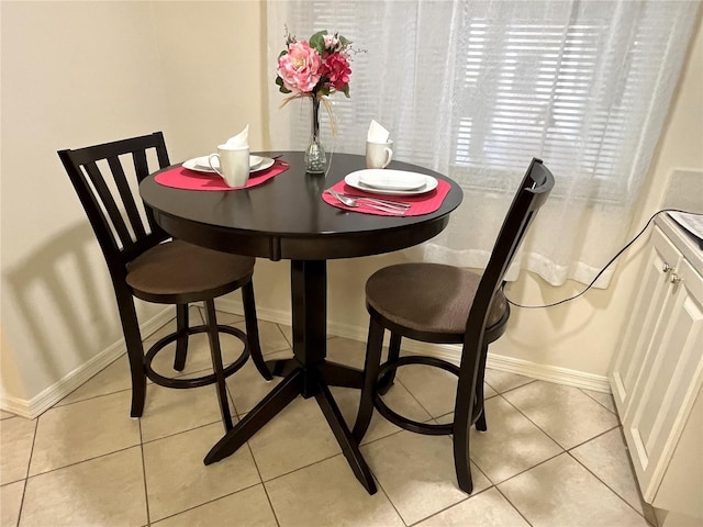 dining space featuring light tile patterned floors and baseboards