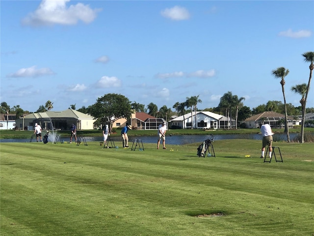 surrounding community featuring a lawn and a water view