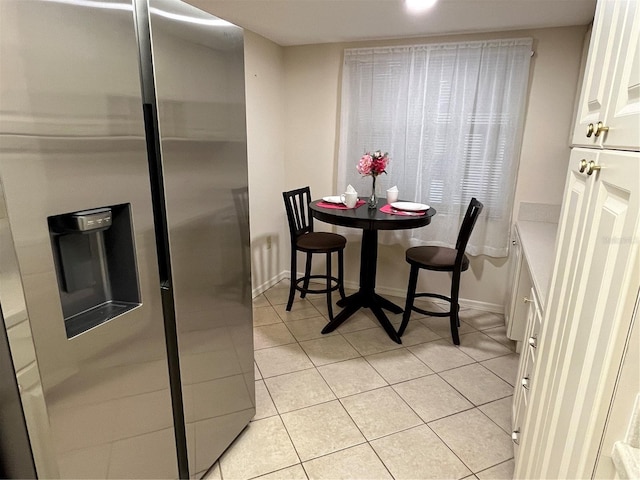 dining area featuring light tile patterned flooring and baseboards