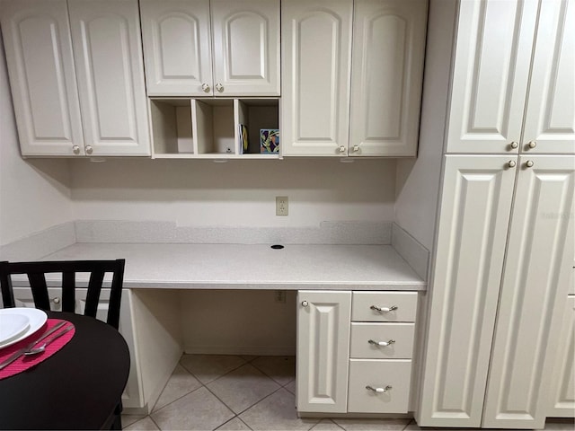 office space featuring built in desk and light tile patterned flooring