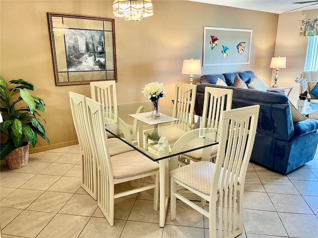 dining area featuring baseboards, a chandelier, and light tile patterned flooring