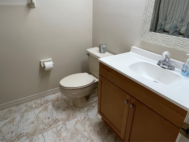 bathroom featuring baseboards, vanity, and toilet