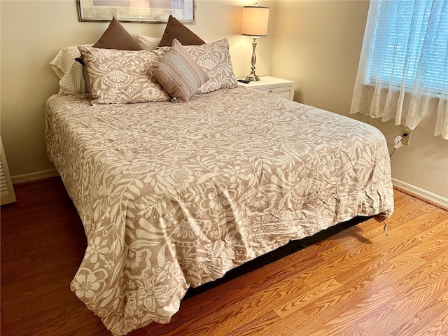 bedroom featuring baseboards and wood finished floors