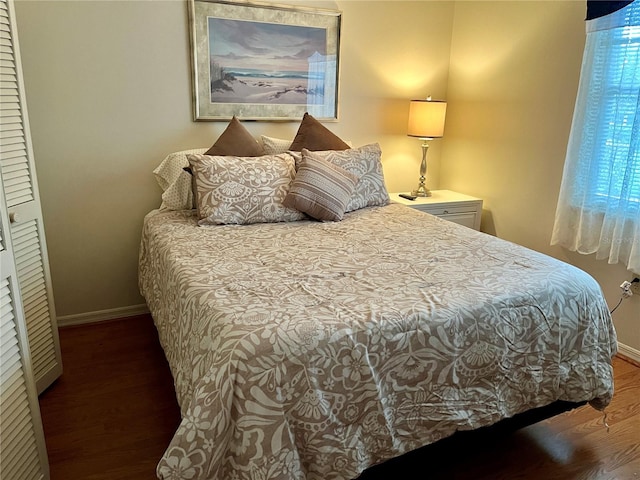 bedroom with dark wood-style flooring and baseboards