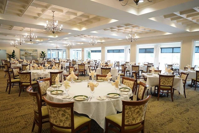 dining area with a chandelier, ornamental molding, coffered ceiling, and carpet